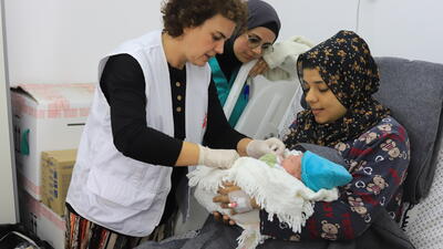MSF medical staff discussing with patient and checking on newborn child in the Emirati hospital, Rafah, southern Gaza.