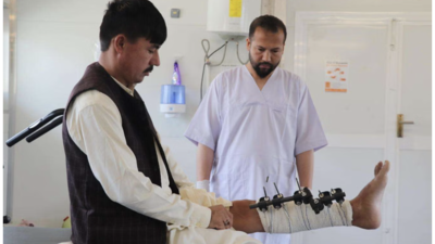 An MSF physiotherapist assists a patient with leg exercises in the physiotherapy department of the MSF trauma center in Kunduz province.