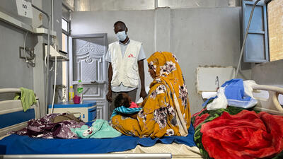 Ferdos holds her 11-month-old baby, Banan, who is infected with measles, in the isolation ward at El Geneina Teaching Hospital, supported by MSF. War forced Ferdos and her family to flee to El Geneina, where they live in overcrowded conditions with other families. Her son contracted measles and infected his 11-month-old daughter.