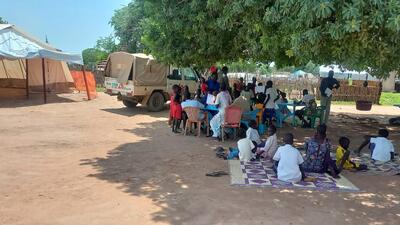 Families wait under the shade of a tree at a seasonal malaria prevention campaign site in Twic County. Through community-based services, MSF and local health authorities are expanding access to preventive care for children most at risk of malaria.