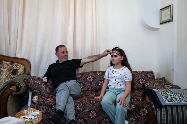 Yasser Abu Markhiyeh shows his daughter's eye following a settler attack when she was an infant, in his home in Hebron on 2 May 2023