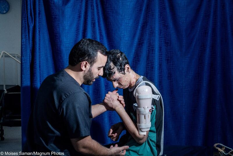 Header: Karam (17) from Gaza training his arm strength and mobility during a physiotherapy session in the hospital. Reconstructive Surgery Hospital, Amman, Jordan, 2024.
