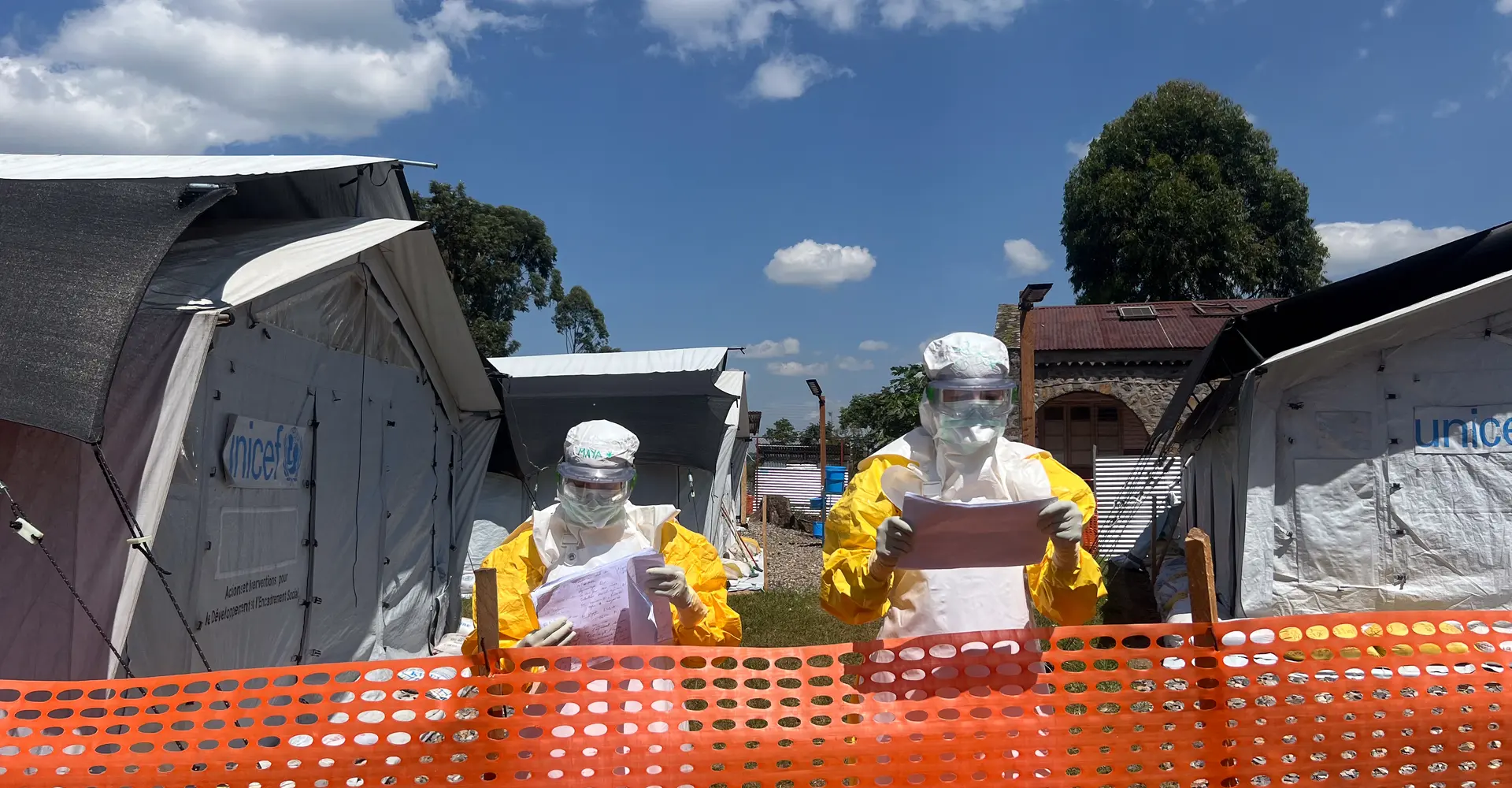 MSF medical teams debrief from the red zone after patient rounds, communicating with medical staff in the green zone. Patient files are considered contaminated and remain in the red zone, with information relayed verbally to ensure infection prevention measures are maintained at the Ebola Treatment Centre in Lwiro, South Kivu.
